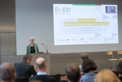 Eine Person präsentiert beim PePP-Netzwerktreffen 2023 in einem Konferenzraum vor einem Publikum.