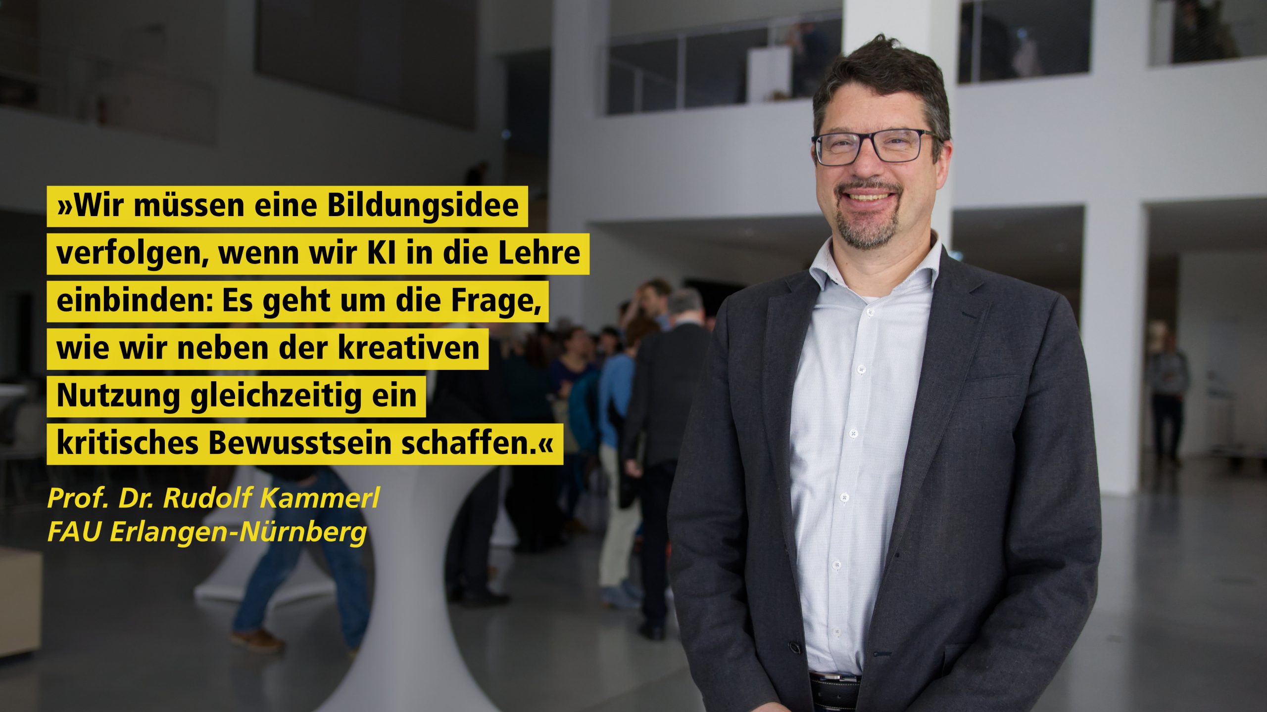 Ein lächelnder Mann steht in einem modernen Gebäude. Zitat von ihm, Prof. DR. Rudolf Kammerl, FAU Erlangen-Nürnberg: "Wir müssen eine Bildungsidee verfolgen, wenn wir KI in die Lehre einbinden: Es geht um die Frage, wie wir neben der kreativen Nutzung gleichzeitig ein kritisches Bewusstsein schaffen."