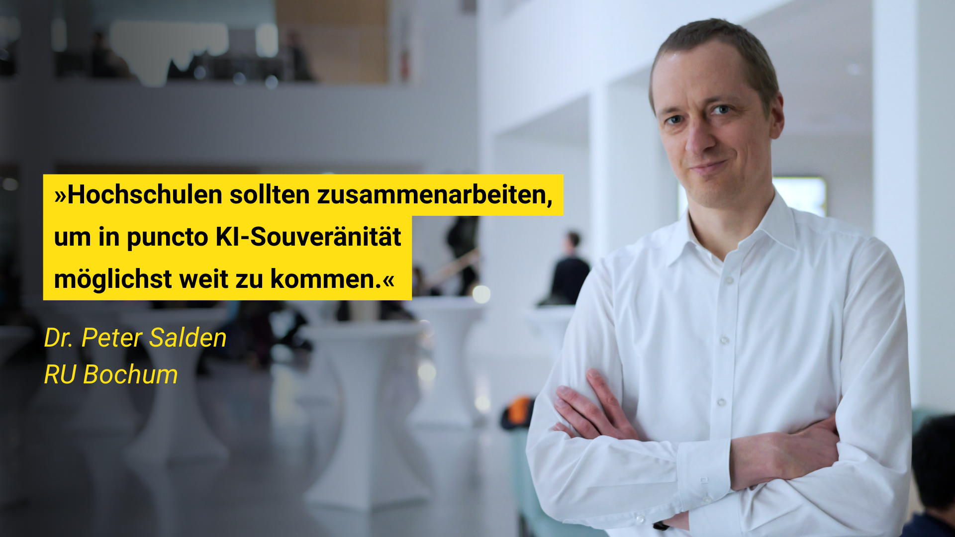 Person in weißem Hemd mit verschränkten Armen steht vor unscharfem Hintergrund. Zitat über KI-Kooperation neben ihr.